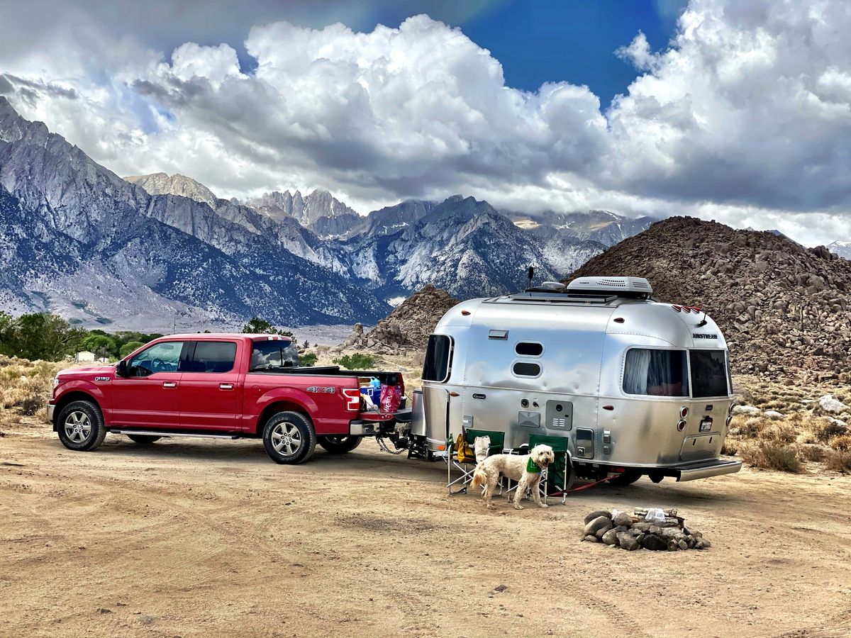 Solar panels mounted on an RV roof in a sunny campground